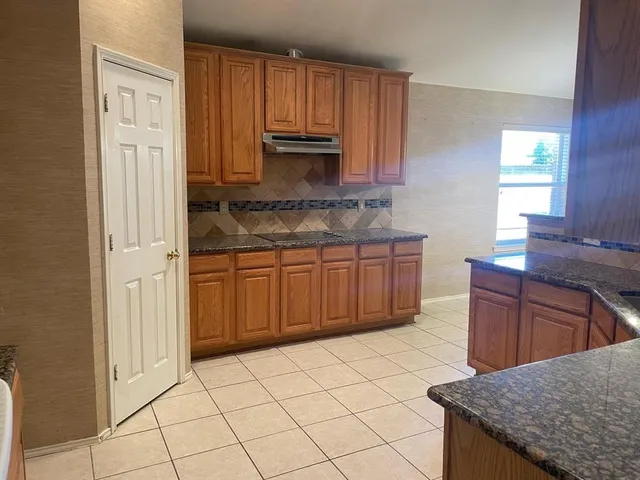 a kitchen with stainless steel appliances granite countertop a stove a sink and a refrigerator