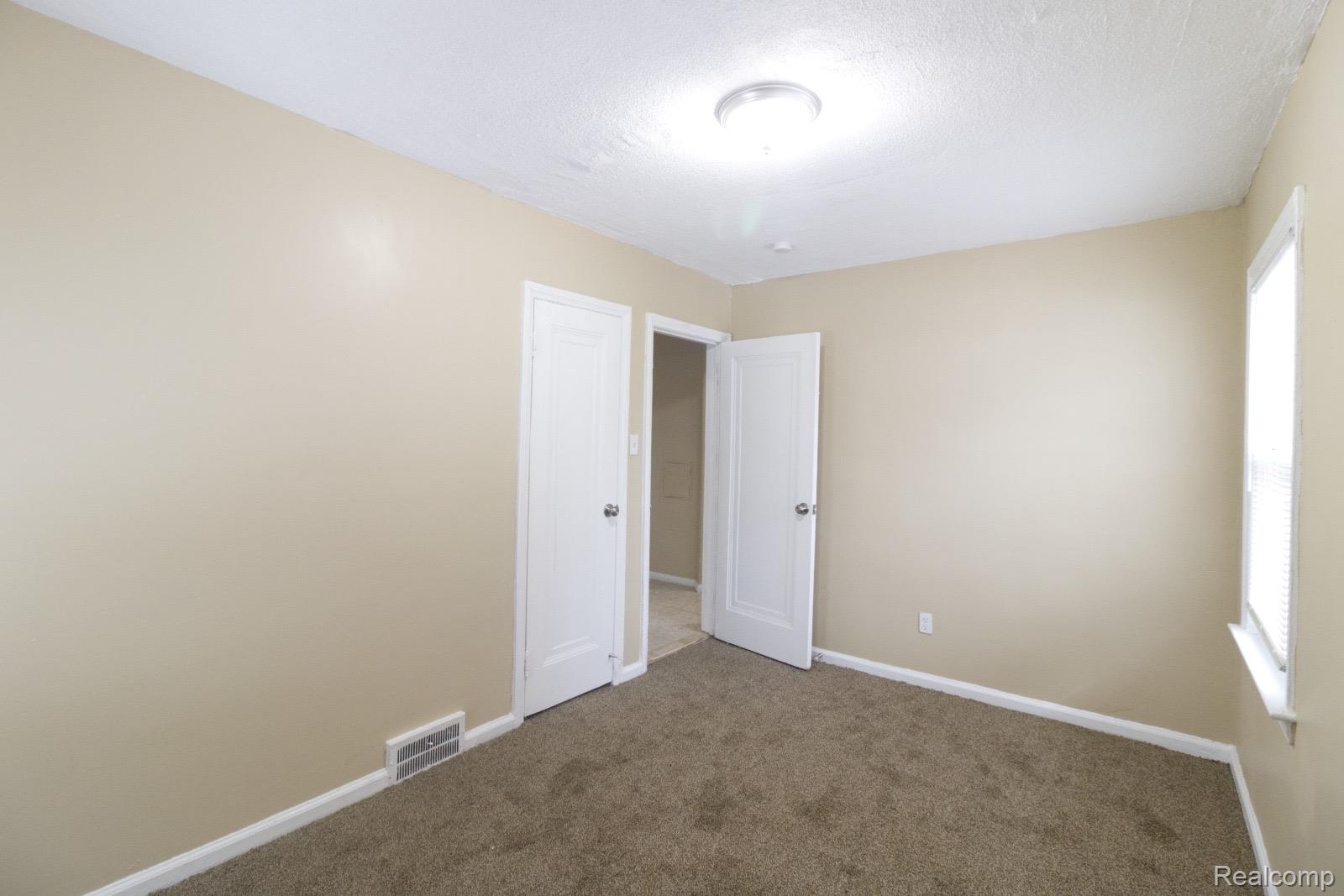 8096 Chamberlain Street Detroit, MI 48209 - Photo 5 of 10 Empty room with carpet and a textured ceiling