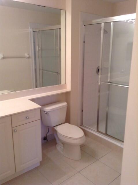 4610 PGA Boulevard, Unit 305 Palm Beach Gardens, FL 33418 - Photo 5 of 10 a bathroom with a toilet a sink a shower and a window