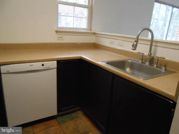a close view of a sink and cabinets in an empty room