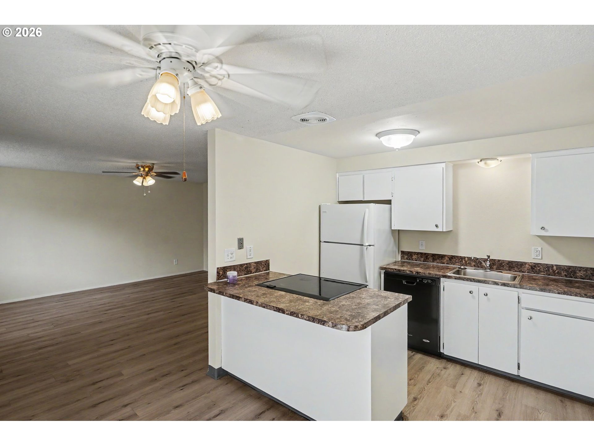 777 Boone Road Southeast, Unit 12 Salem, OR 97302 - Photo 8 of 16 a kitchen with granite countertop a stove a sink dishwasher and white cabinets with wooden floor