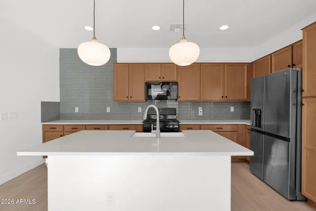 a kitchen with stainless steel appliances granite countertop a sink a refrigerator and a stove