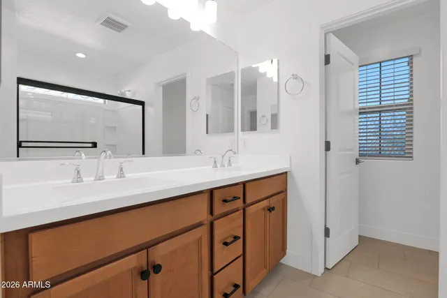 a bathroom with a double vanity sink and a mirror