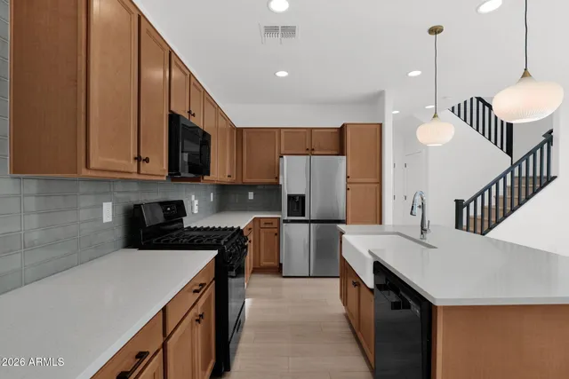 a kitchen with a sink a microwave a refrigerator and cabinets