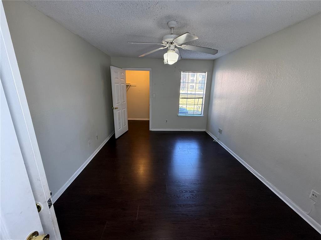5500 Devonbriar Way, Unit 104 Orlando, FL 32822 - Photo 12 of 24 a view of an empty room with wooden floor and a window