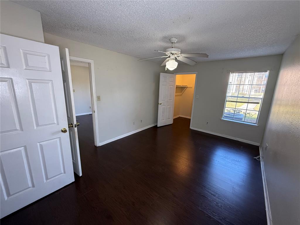 5500 Devonbriar Way, Unit 104 Orlando, FL 32822 - Photo 13 of 24 an empty room with wooden floor and windows