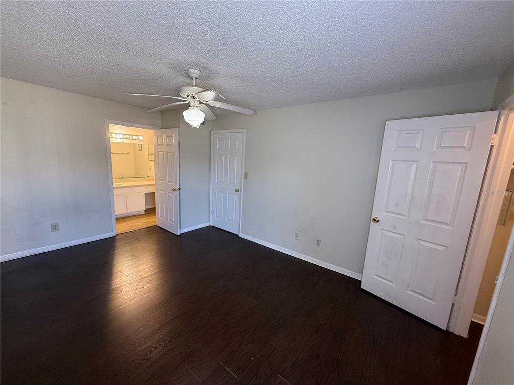 5500 Devonbriar Way, Unit 104 Orlando, FL 32822 - Photo 14 of 24 an empty room with wooden floor and fan