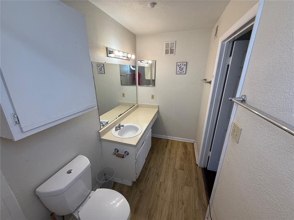 5500 Devonbriar Way, Unit 104 Orlando, FL 32822 - Photo 16 of 24 a bathroom with a toilet sink and mirror