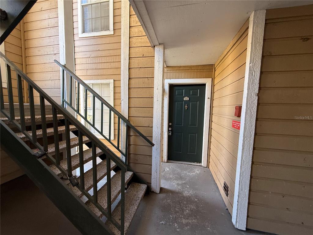 5500 Devonbriar Way, Unit 104 Orlando, FL 32822 - Photo 19 of 24 a view of a balcony with wooden floor and stairs