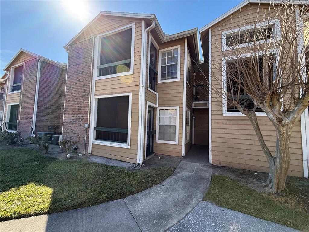 5500 Devonbriar Way, Unit 104 Orlando, FL 32822 - Photo 21 of 24 a view of a brick house with many windows next to a yard