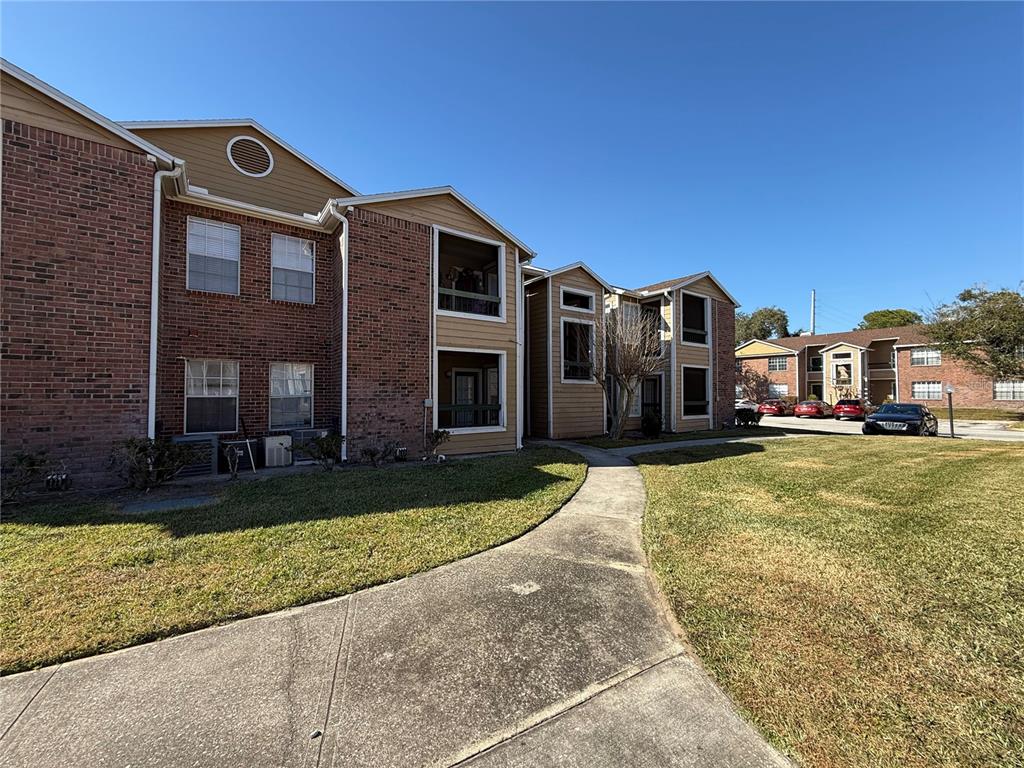 5500 Devonbriar Way, Unit 104 Orlando, FL 32822 - Photo 22 of 24 a front view of a house with a yard