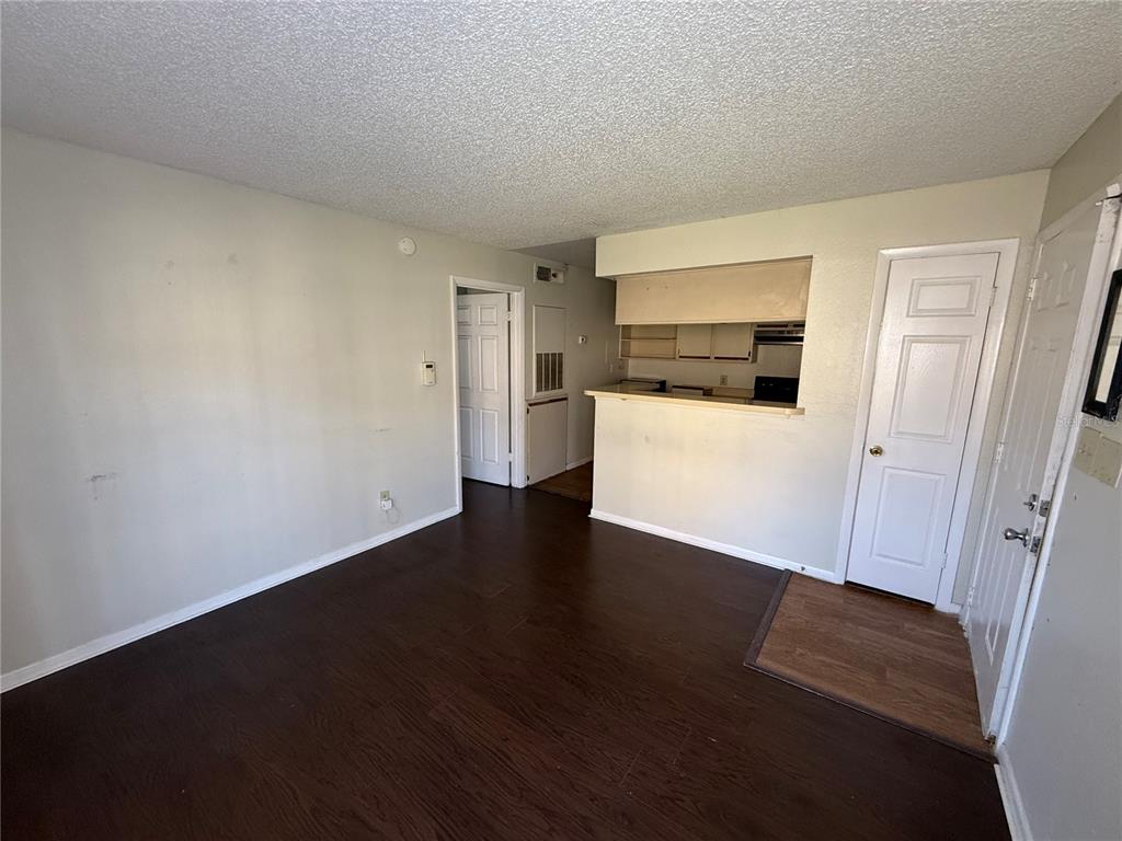 5500 Devonbriar Way, Unit 104 Orlando, FL 32822 - Photo 4 of 24 a view of a room with wooden floor and electronic appliances
