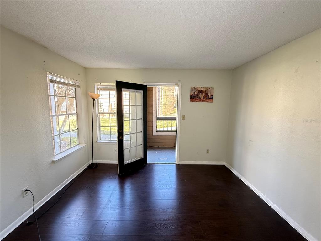 5500 Devonbriar Way, Unit 104 Orlando, FL 32822 - Photo 5 of 24 an empty room with wooden floor and windows