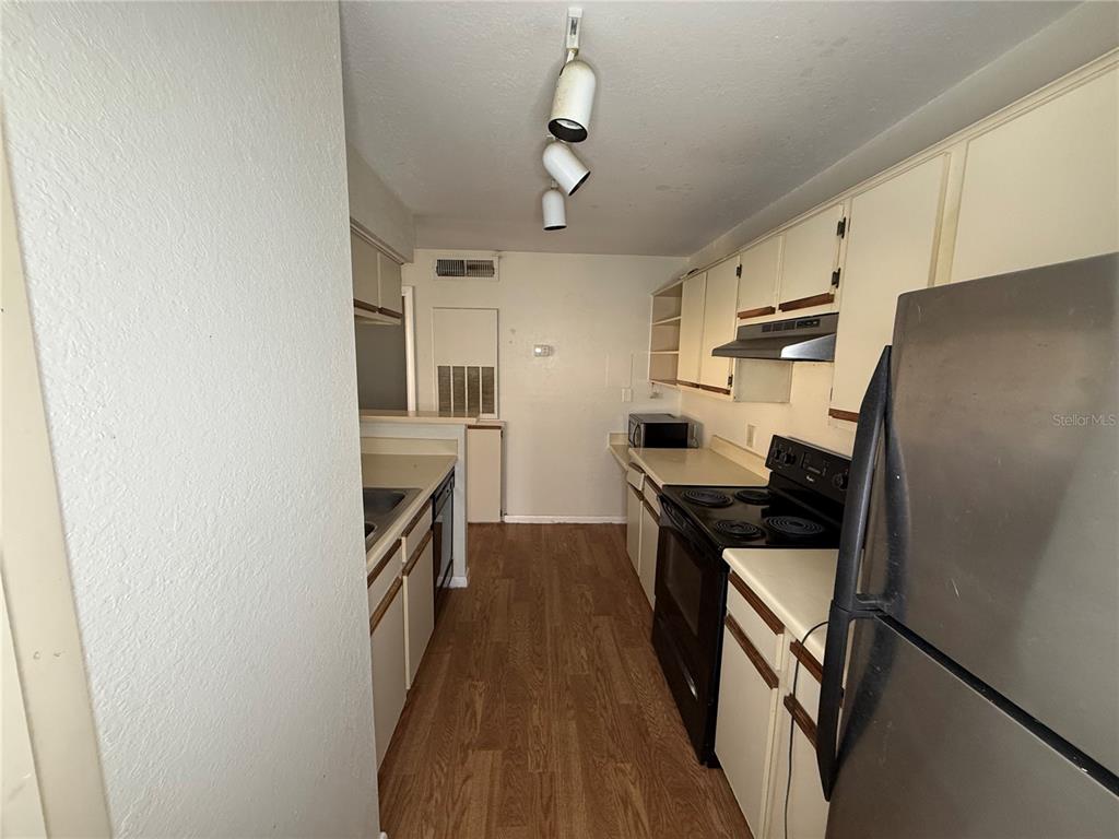 5500 Devonbriar Way, Unit 104 Orlando, FL 32822 - Photo 9 of 24 a kitchen with a refrigerator a stove top oven a sink and dishwasher