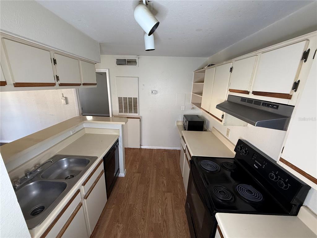 5500 Devonbriar Way, Unit 104 Orlando, FL 32822 - Photo 10 of 24 a kitchen with a stove and a refrigerator