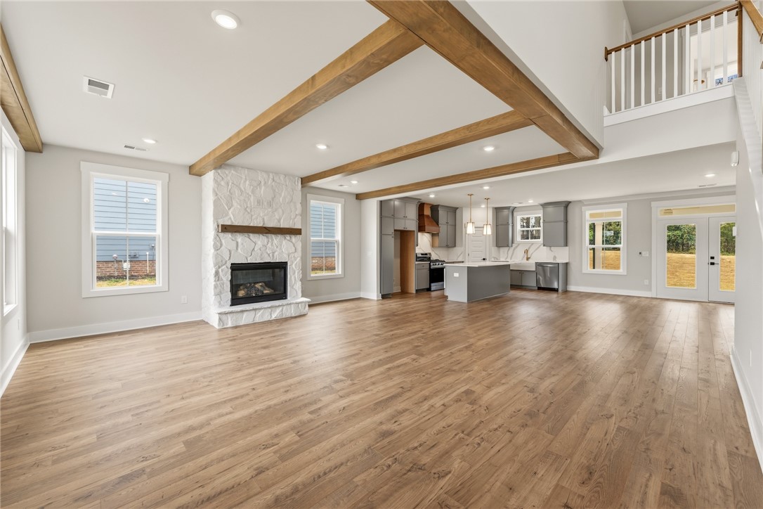 319 Summerall Drive Anderson, SC 29621 - Photo 3 of 37 This expansive open-concept living area features a modern kitchen, inviting fireplace, and rich wood flooring.
