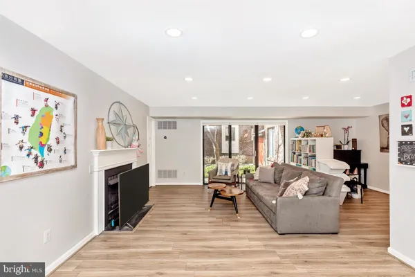 a living room with furniture large window and wooden floor