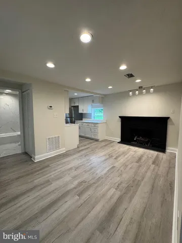 wooden floor in an empty room with a kitchen