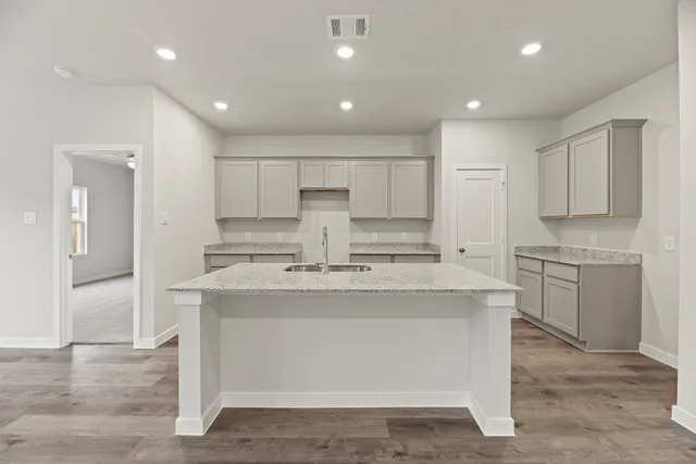 a kitchen with kitchen island sink stove and white cabinets
