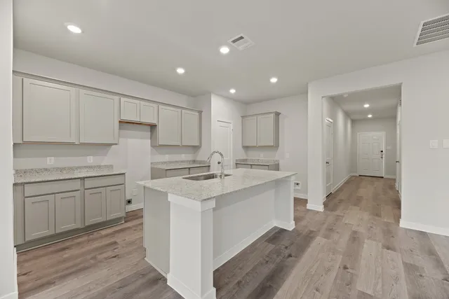 a kitchen with white cabinets appliances and sink