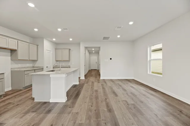 a kitchen with a sink and wooden floor