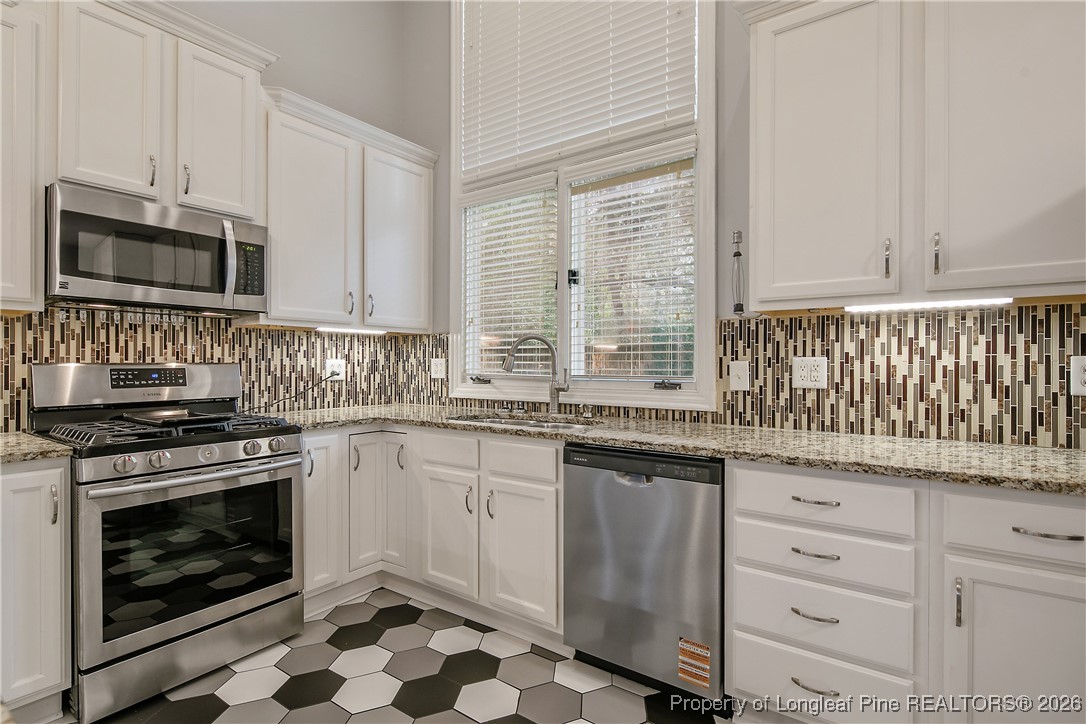 1915 Morganton Road Fayetteville, NC 28305 - Photo 12 of 48 a kitchen with stainless steel appliances granite countertop a stove a sink and a microwave