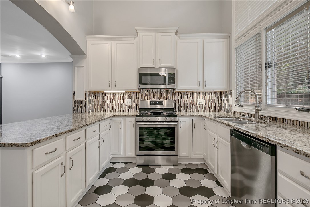 1915 Morganton Road Fayetteville, NC 28305 - Photo 13 of 48 a kitchen with stainless steel appliances granite countertop a sink stove and cabinets
