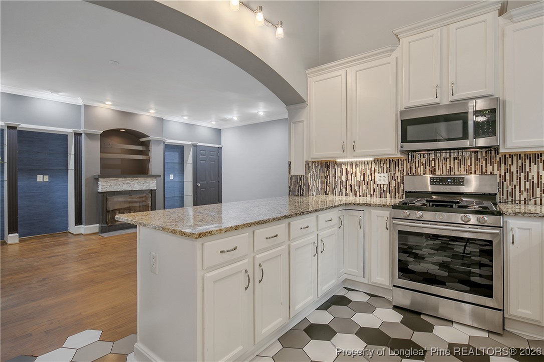 1915 Morganton Road Fayetteville, NC 28305 - Photo 14 of 48 a kitchen with stainless steel appliances granite countertop a stove microwave and cabinets
