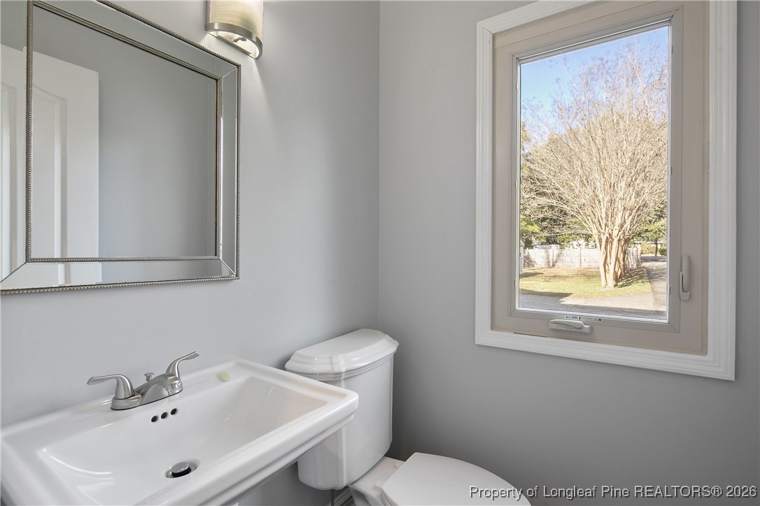 1915 Morganton Road Fayetteville, NC 28305 - Photo 18 of 48 a bathroom with a sink mirror and toilet