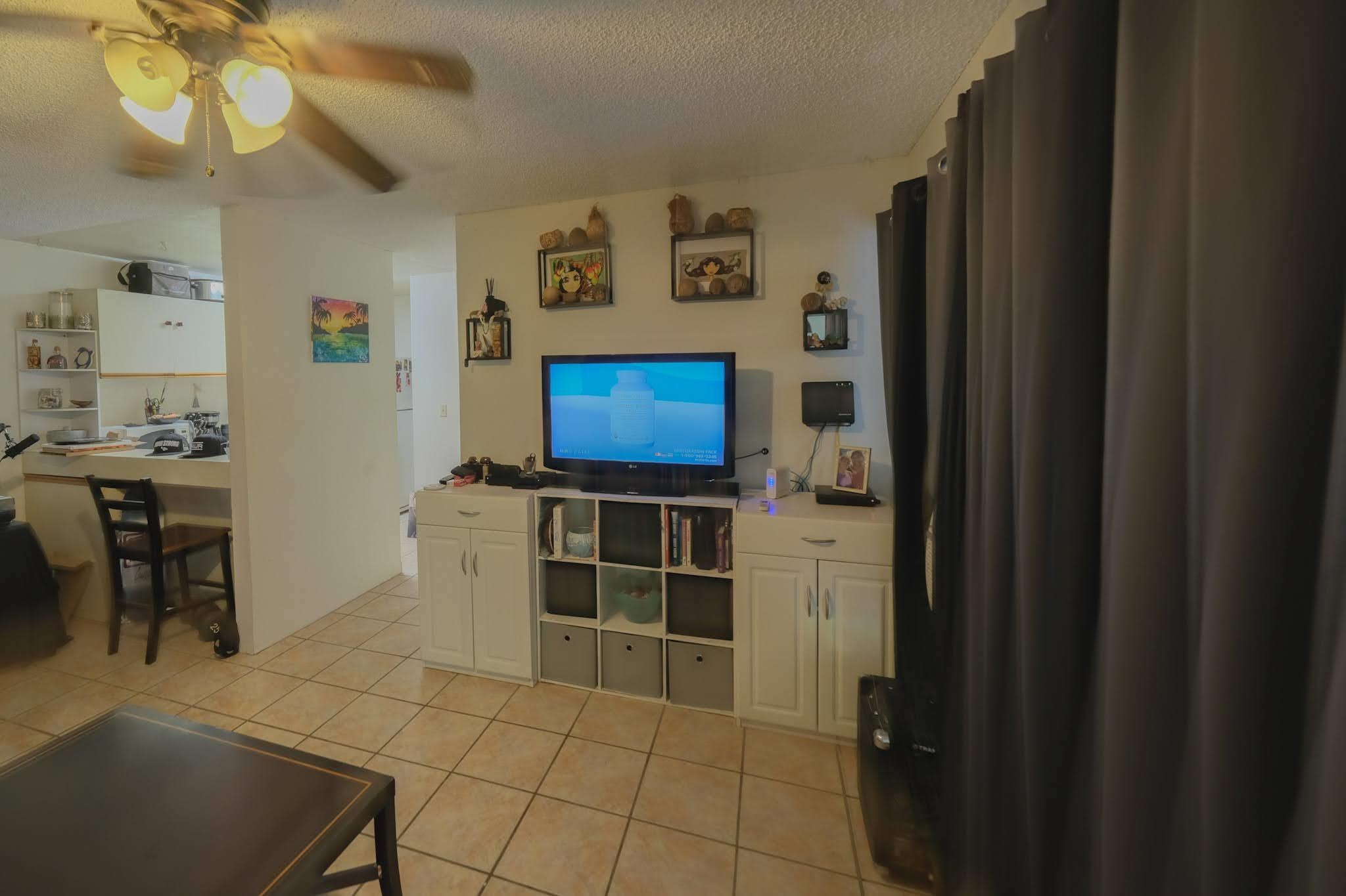 160 Keonekai Road, Unit 13206 Kihei, HI 96753 - Photo 4 of 14 a room with furniture and a flat screen tv
