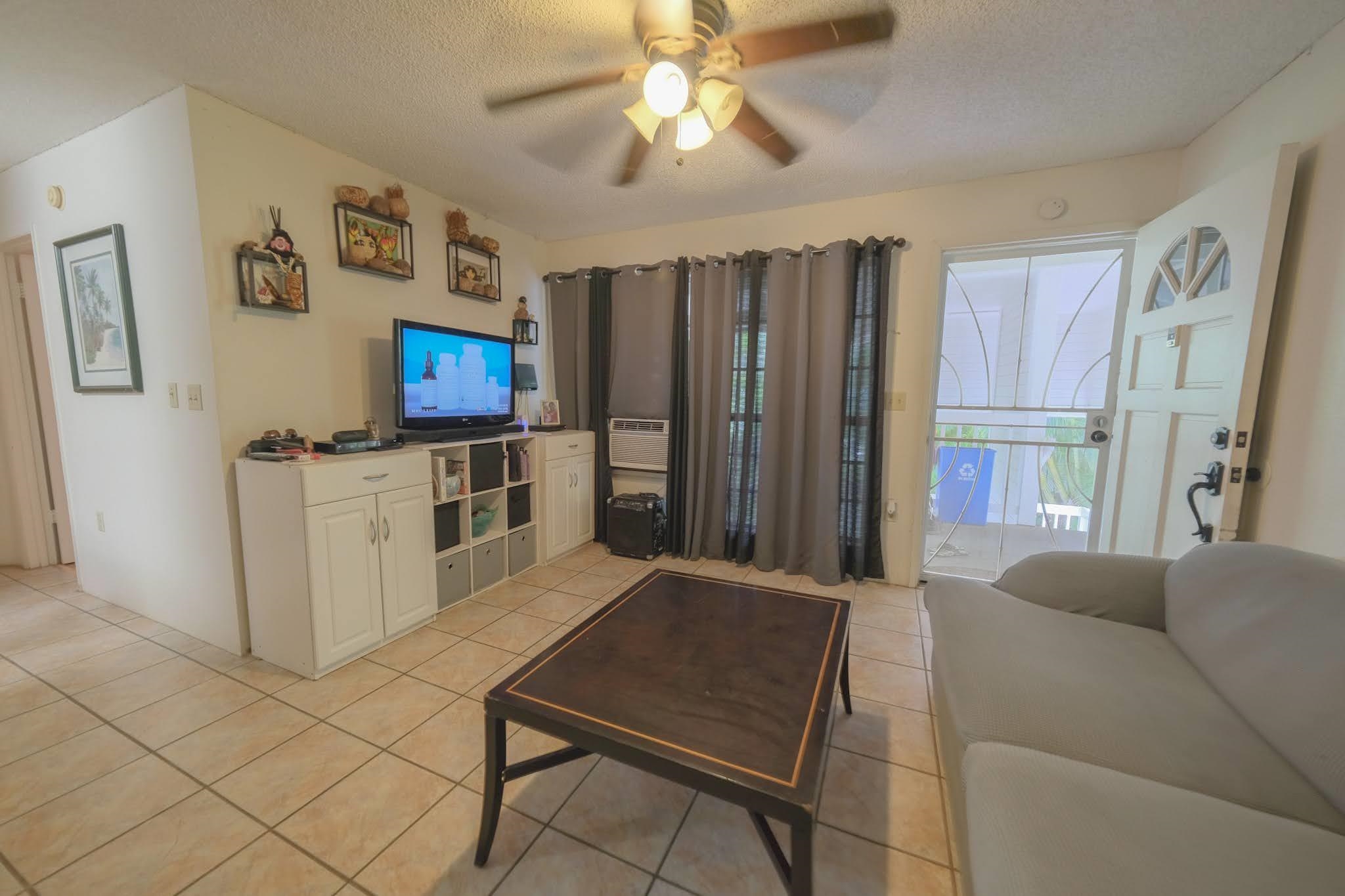 160 Keonekai Road, Unit 13206 Kihei, HI 96753 - Photo 5 of 14 a living room with furniture a flat screen tv and a refrigerator