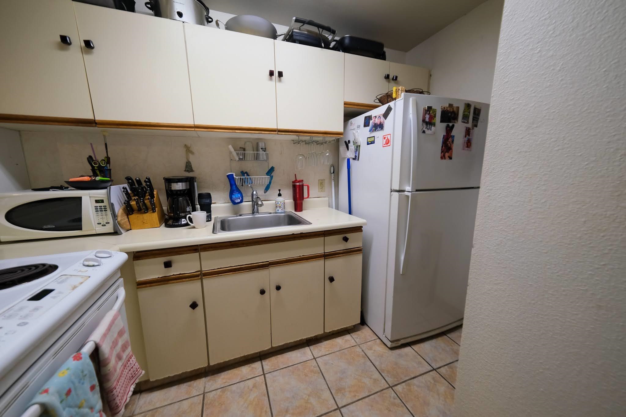 160 Keonekai Road, Unit 13206 Kihei, HI 96753 - Photo 8 of 14 a kitchen with refrigerator and cabinets