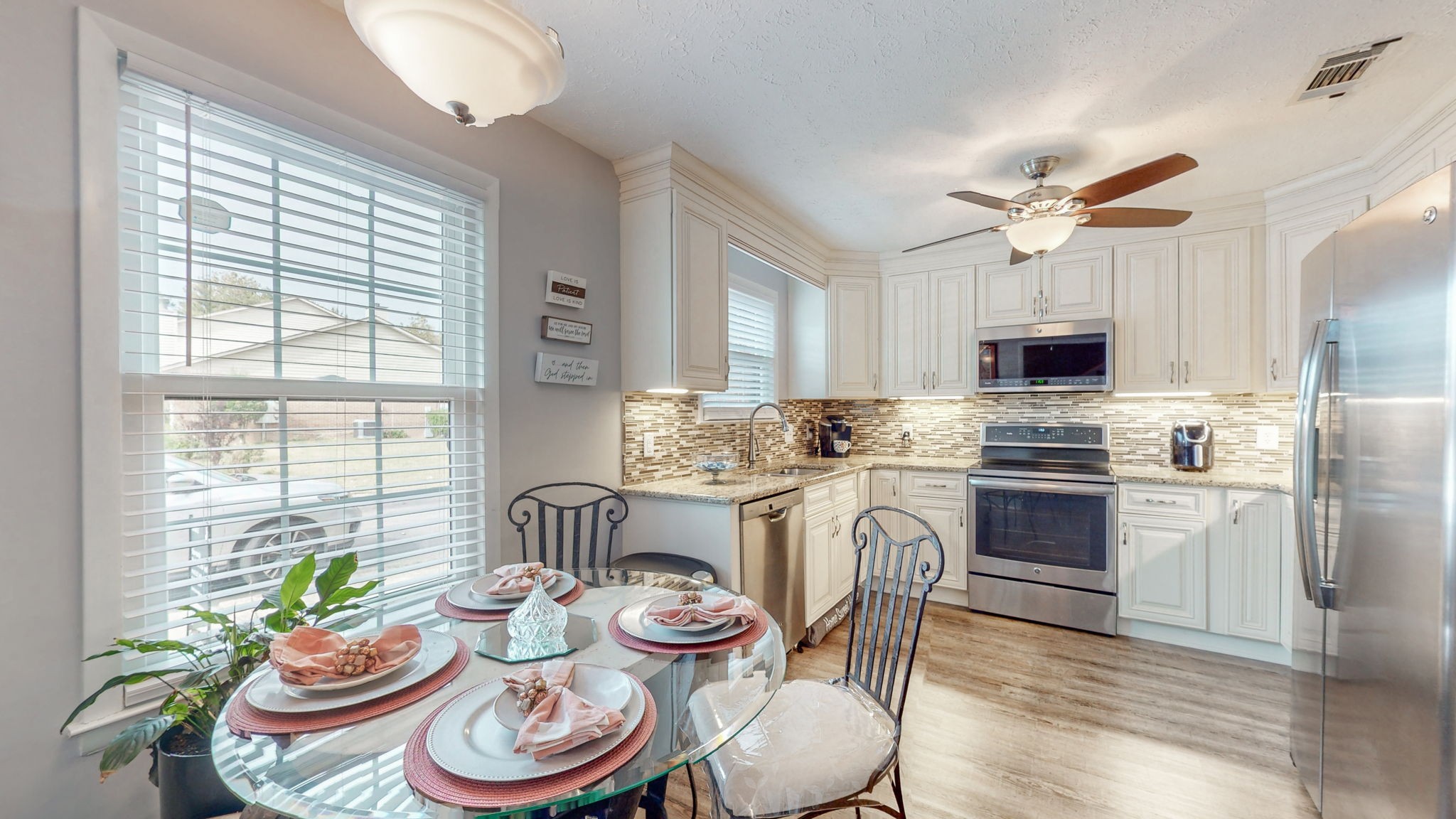 a kitchen with stainless steel appliances a white table and chairs