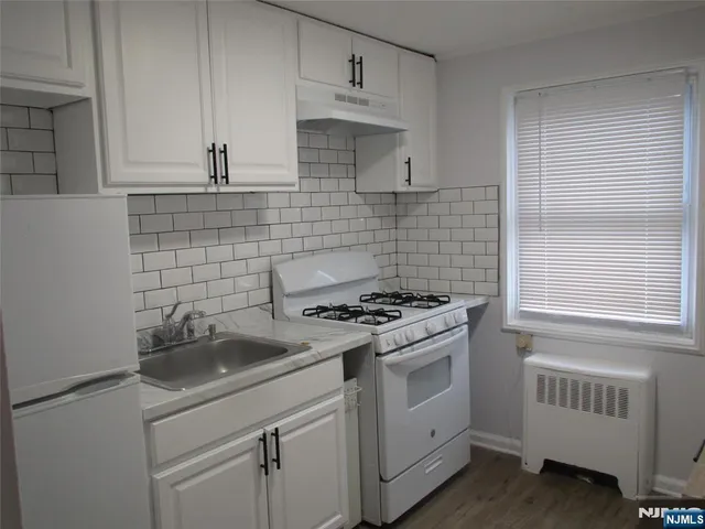 a kitchen with white cabinets and white appliances