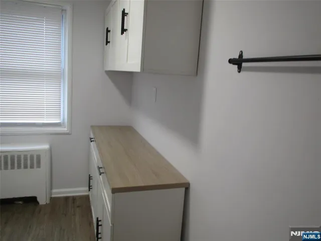 a view of storage and utility room with wooden floor