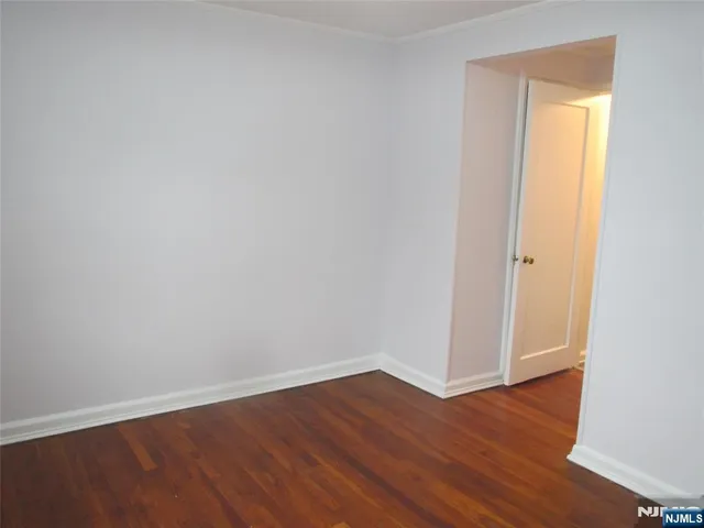 an empty room with wooden floor and closet