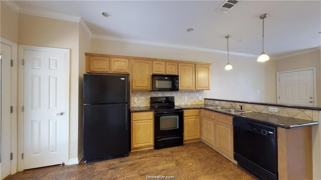 1198 Jones-Butler Road, Unit 706 College Station, TX 77840 - Photo 4 of 8 a kitchen with stainless steel appliances granite countertop a refrigerator a stove a sink and a microwave