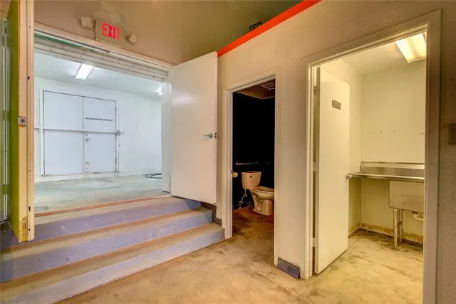 a bathroom with a toilet a sink and mirror