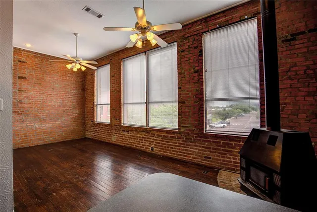 a kitchen with stainless steel appliances a stove a sink dishwasher a refrigerator white cabinets and wooden floor