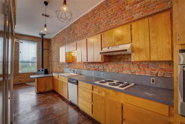 a view of a kitchen with refrigerator and a stove
