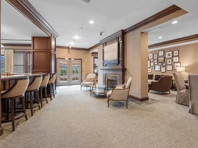 a living room with furniture a fireplace and large windows