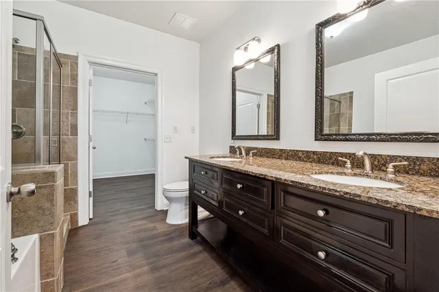 a bathroom with a granite countertop sink a toilet and a mirror