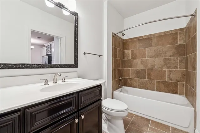 a bathroom with a bathtub shower sink vanity and toilet