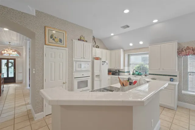 a kitchen with stainless steel appliances kitchen island granite countertop a sink and cabinets