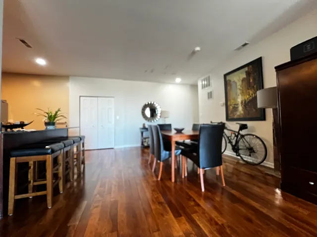 a view of a dining room with furniture kitchen appliances and wooden floor