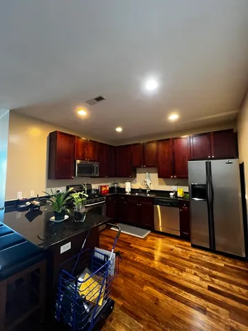a kitchen with stainless steel appliances granite countertop a stove refrigerator sink and cabinets