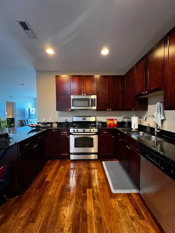 a kitchen with granite countertop stainless steel appliances and wooden cabinets