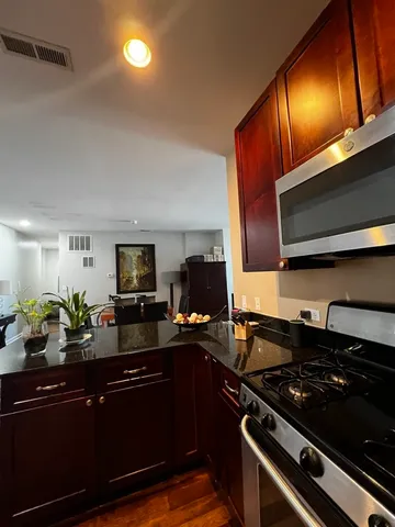 a kitchen with granite countertop stainless steel appliances and cabinets