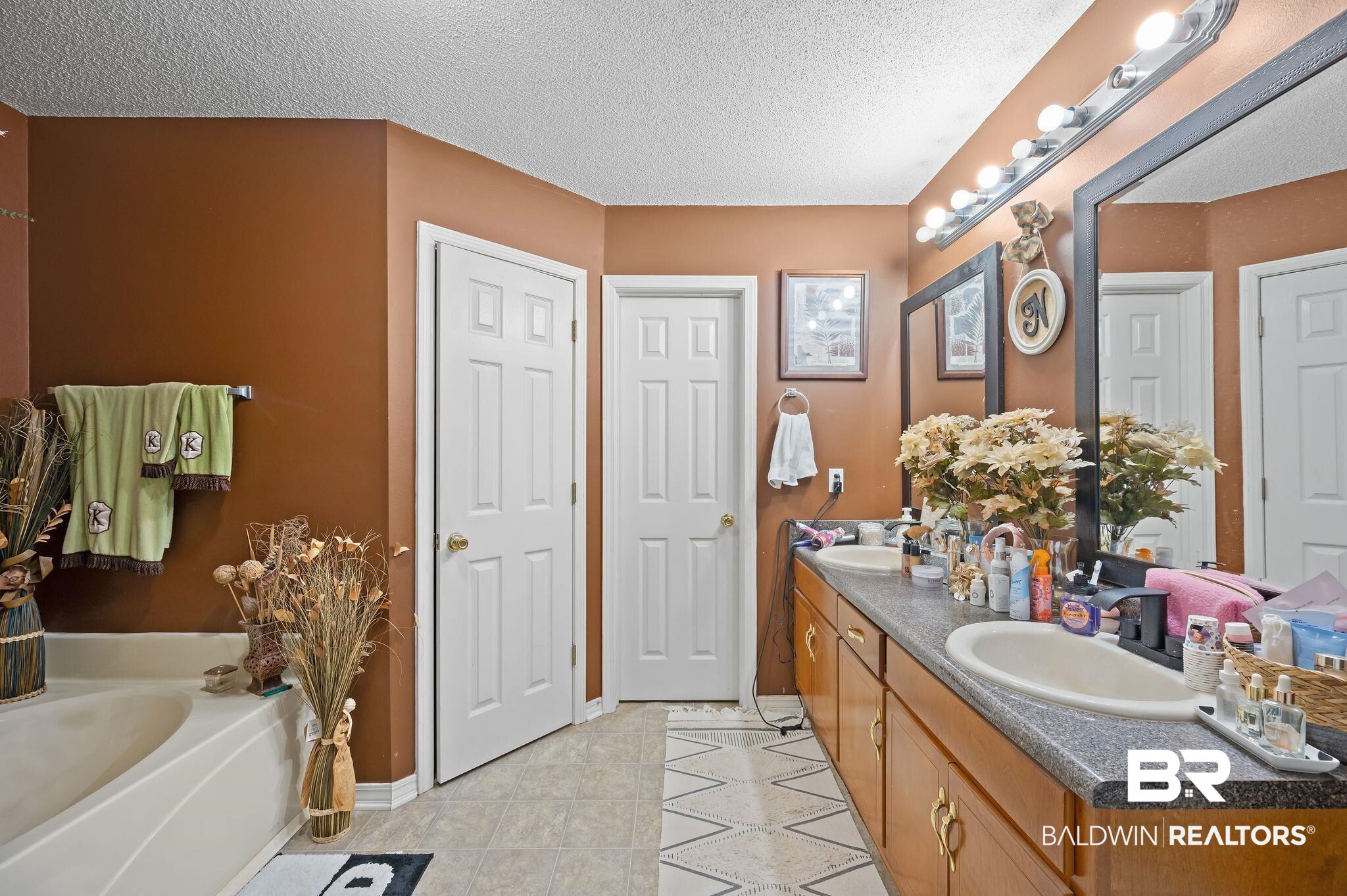 52923 Ammons Road Perdido, AL 36562 - Photo 21 of 35 Full bathroom with double vanity, a bath, a textured ceiling, and tile patterned flooring