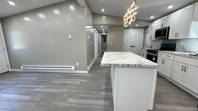 a kitchen with kitchen island a sink stainless steel appliances and cabinets